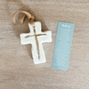 White ceramic cross with gold accents and covered in resin, accompanied by a Psalm 23 bookmark